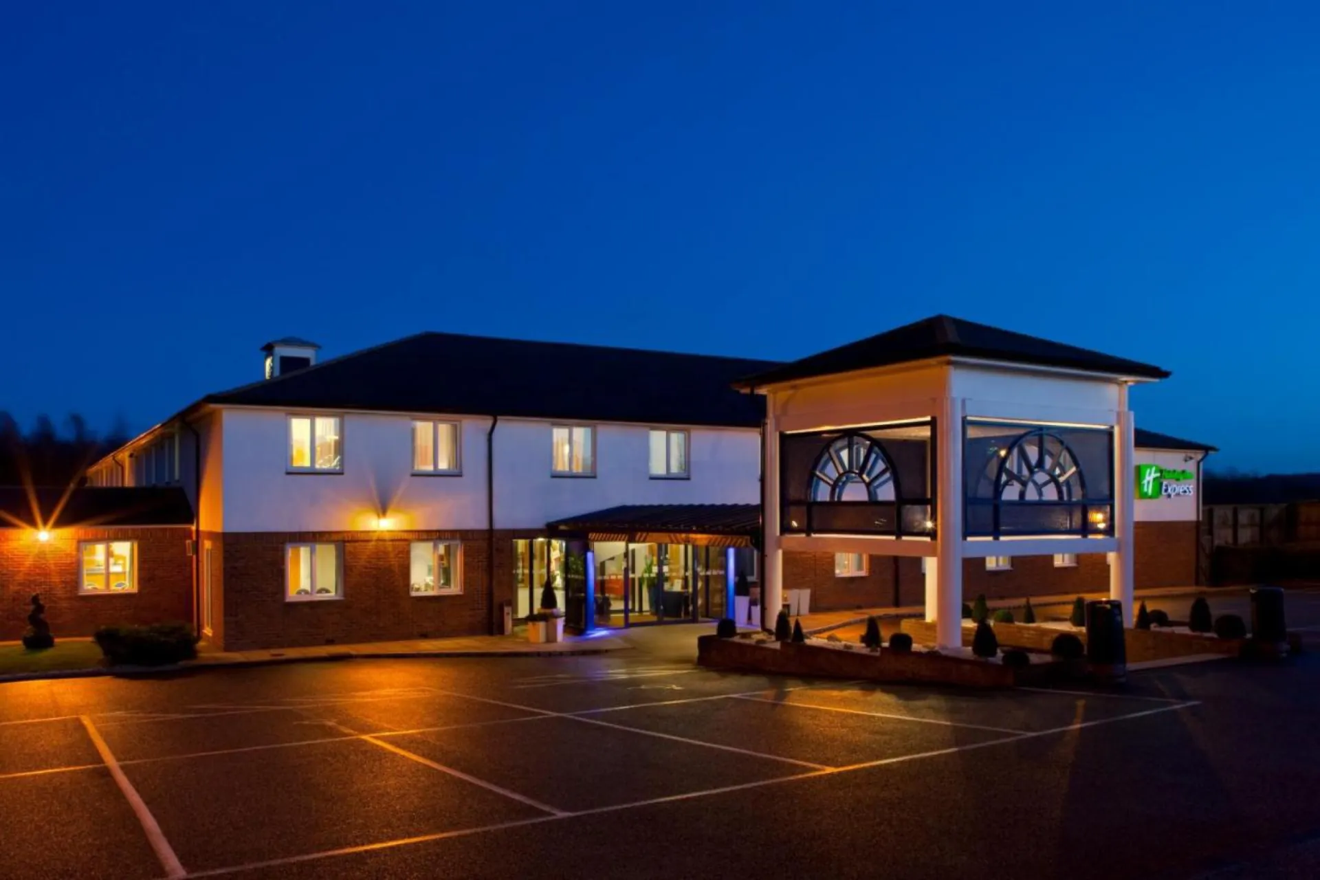 Holiday Inn Express at blue hour, lit windows and porte-cochère
