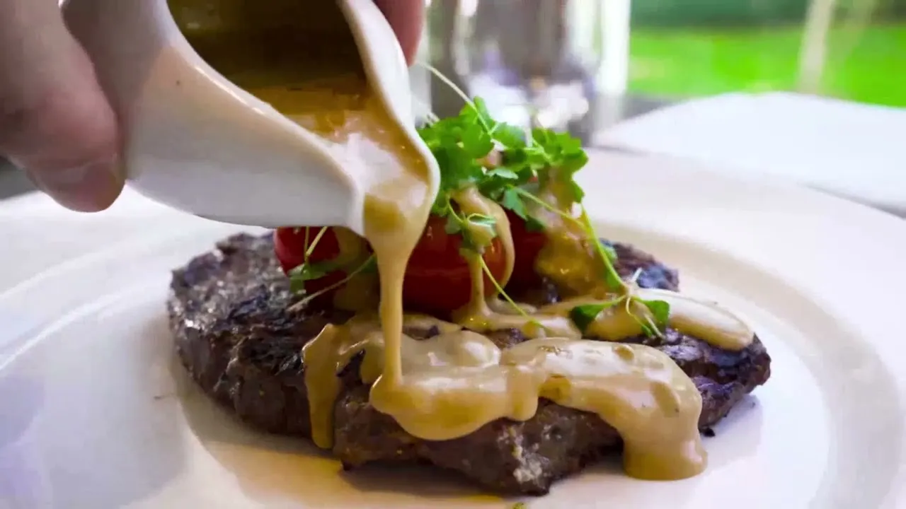 Peppercorn sauce poured over a steak at Marco Pierre White Steakhouse